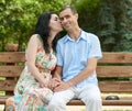 Romantic couple kiss on bench in city park, summer season, adult happy people man and woman Royalty Free Stock Photo