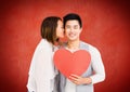 Romantic couple kissing with valentines heart against red background Royalty Free Stock Photo