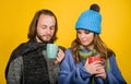 Romantic couple in knitted hats, scarves and sweaters drinking hot tea. Smiling family man woman in winter wear with Royalty Free Stock Photo