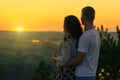 Romantic couple look on sun, evening on outdoor, beautiful landscape and bright yellow sky, love tenderness concept, young adult Royalty Free Stock Photo