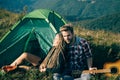 Romantic couple in love camping outdoors and sitting near tent. Happy Man and woman on a romantic camping vacation. Royalty Free Stock Photo