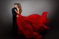 Romantic Couple in Love dancing. Man in Black Shirt Embracing Mysterious Girl in Flying Red Dress. Fashion Woman in Long Gown