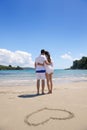 Romantic couple in love have fun on the beach with heart drawi Royalty Free Stock Photo