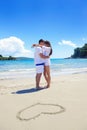 Romantic couple in love have fun on the beach with heart drawi Royalty Free Stock Photo