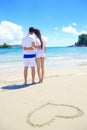 Romantic couple in love have fun on the beach with heart drawi Royalty Free Stock Photo