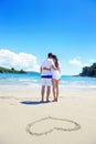 Romantic couple in love have fun on the beach with heart drawi Royalty Free Stock Photo