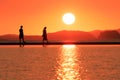 romantic couple in love sitting together on rope swing at sunset beach, silhouettes of young man and woman on holidays or Royalty Free Stock Photo