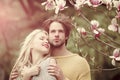 Romantic couple in love in spring garden at beautiful blooming magnolia tree. Royalty Free Stock Photo