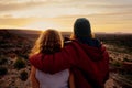 Romantic couple in love standing and embracing and watching mountain landscape in sunrise morning