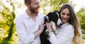 Romantic couple in love walking dogs in nature and smiling Royalty Free Stock Photo