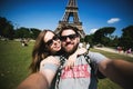 Romantic couple making selfie in front of Eiffel
