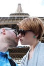 Romantic couple making selfie in front of Eiffel Tower while traveling in Paris, France. Students enjoy their vacation