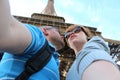 Romantic couple making selfie in front of Eiffel Tower while traveling in Paris, France. Students enjoy their vacation