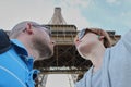 Romantic couple making selfie in front of Eiffel Tower while traveling in Paris, France. Students enjoy their vacation