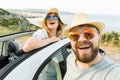 Romantic couple making selfie on smartphone camera in rental cabrio car on ocean or sea beach enjoying summer vacation Royalty Free Stock Photo