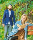 Romantic couple meet in park. woman read intersting book. relax on park bench. Literature. autumn or spring time