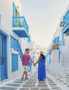 Romantic couple of men and women at the street of Mykonos Greek village in Greece