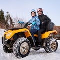 Romantic couple outdoor in winter in wild nature on yellow ATV
