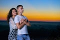 Romantic couple portrait at sunset on outdoor, beautiful landscape and bright yellow sky, love tenderness concept, young adult Royalty Free Stock Photo