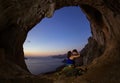 Romantic couple of rock climbers in cave at sunset Royalty Free Stock Photo