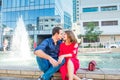 Romantic couple sitting on the bench near the city fountain and enjoying moments of happiness. Love, dating, romance. Lifestyle an