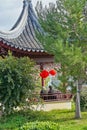 Romantic couple sitting in Chinese gazebo in garden with oriental red traditional lantern