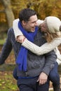 Romantic Couple Sitting On Fence In Autumn Woodland Royalty Free Stock Photo