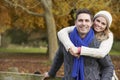 Romantic Couple Sitting On Fence In Autumn Woodland Royalty Free Stock Photo