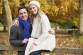 Romantic Couple Sitting On Fence In Autumn Woodland Royalty Free Stock Photo