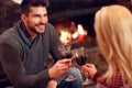 Romantic couple sitting on floor at burning fireplace and drink Royalty Free Stock Photo