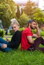 Romantic couple sitting on green grass in park. Royalty Free Stock Photo
