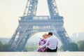 Romantic couple sitting near the Eiffel tower in Paris, France