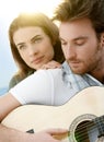 Romantic couple sitting playing guitar outdoor Ã¯Â¿Â½ Royalty Free Stock Photo