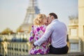Romantic couple sitting on the roof near the Eiffel tower in Paris, France Royalty Free Stock Photo