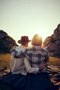 Romantic couple watching sunset on summer hike Royalty Free Stock Photo