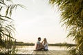 Romantic couple sitting on the wooden pier on the lake Royalty Free Stock Photo