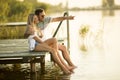 Romantic couple sitting on the wooden pier on the lake Royalty Free Stock Photo