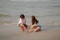 Romantic couple sitting and writing on the sand at the beach in sunset. plan life insurance at future concept.