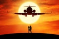Romantic couple standing under flying aircraft Royalty Free Stock Photo
