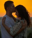 Romantic couple at sunset on outdoor, beautiful landscape and bright yellow sky, love tenderness concept, young adult people