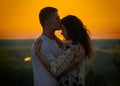 Romantic couple at sunset on outdoor, beautiful landscape and bright yellow sky, love tenderness concept, young adult people Royalty Free Stock Photo