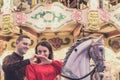 Romantic couple taking a moment to kiss while riding horses on carousel Royalty Free Stock Photo