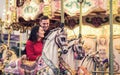 Romantic couple taking a moment to kiss while riding horses on carousel Royalty Free Stock Photo