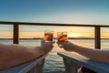 Romantic couple toasting drinks seaside at sunset Royalty Free Stock Photo