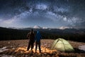 Romantic couple tourists enjoying in the camping at night under beautiful night sky full of stars and milky way Royalty Free Stock Photo