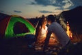 Romantic couple of tourists near the fire sit at to the camping. Royalty Free Stock Photo