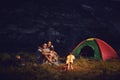 Romantic couple of tourists near the fire sit at to the camping. Royalty Free Stock Photo