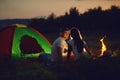 Romantic couple of tourists near the fire sit at to the camping. Royalty Free Stock Photo