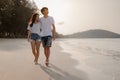 Romantic couple walking holding hands each other while at beach at sunrise, plan life insurance at future concept.