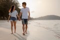 Romantic couple walking holding hands each other while at beach at sunrise, plan life insurance at future concept.